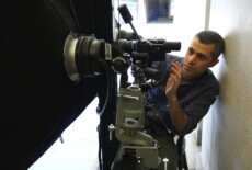 Man handling camera and lighting equipment