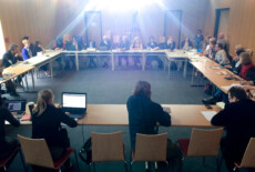 TRACES Kick-Off meeting, Klagenfurt, 2016. Group of people sitting in a conference room around tables arranged in a square.