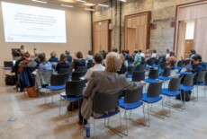 Maria Teschler-Nicola speaking at the Dead Images Conference, Edinburgh College of Art, July 2018. Woman standing and talking to an audience in an event hall.