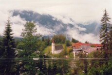 Mösern / Seefeld, Tyrol, 2012 Out of focus picturesque scene of village houses and cloud-covered mountains in the background. In the foreground and in focus is a long bubble level.