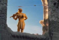 Stadtpark, Vienna, 2012 Out of focus golden sculpture of a man playing violin. In the foreground and in focus is a long bubble level.