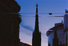 St. Stephen’s cathedral (Stephansdom), Vienna, 2012 Out of focus silhouette of a church's tower and other buildings against darke evening skies. In the foreground and in focus is a long bubble level.