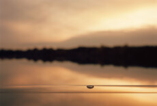 The lake in Viehofen, St. Pölten, Lower Austria, 2012 Out of focus landscape in sunset colors. In the foreground and in focus is a long bubble level.
