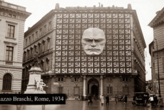 Archival photograph of Palazzo Braschi, Rome, 1934 (AI enhanced). Mussolini's effigy and an all-over repetition of 'SI SI SI' cover the building's facade — a reference to the Fascist plebiscite of that year. At the time, the country was a single-party state with the National Fascist Party (PNF) as the only legally permitted party. Black and white photo of Palazzo Braschi iand two adjacent buildings. Mussolini's effigy and an all-over repetition of 'SI SI SI' cover the building's facade. Text label reads Palazzo Braschi, Rome, 1934.